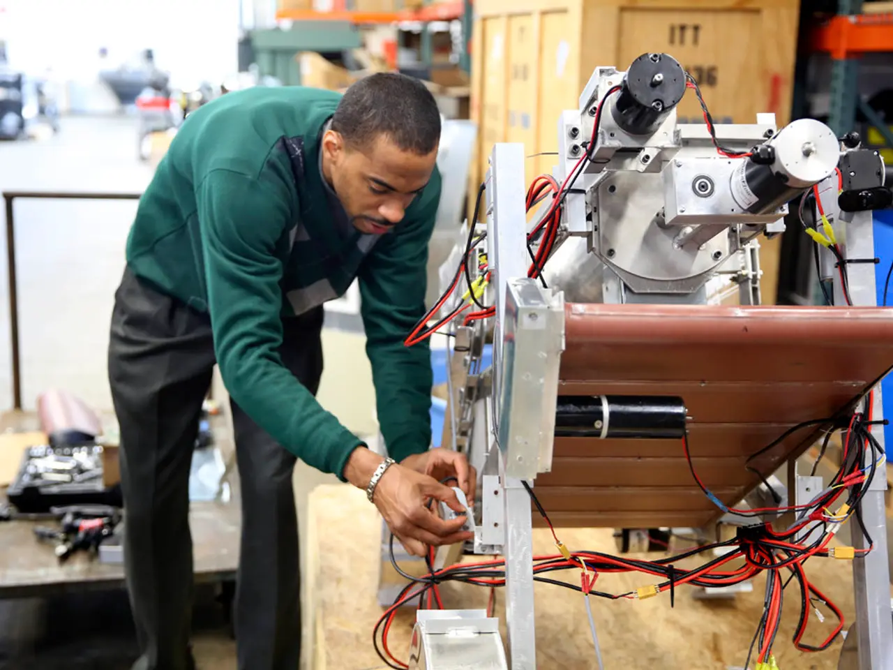 In this picture I can see a man standing and looks like he is fixing a machine and I can see few...