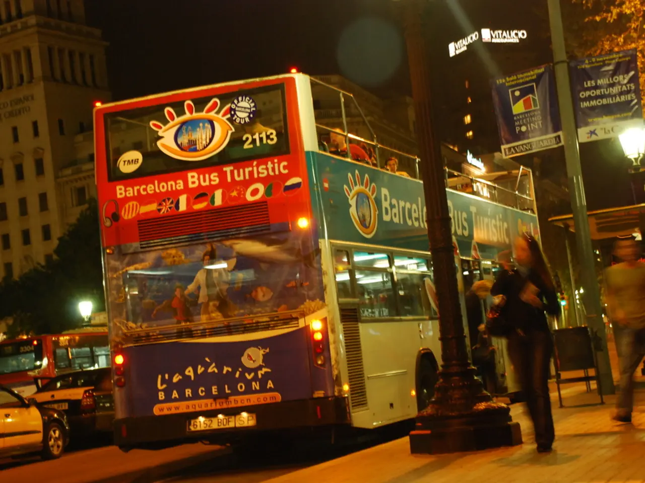 In this image we can see vehicles on the road and there are few persons in riding in a bus on the...