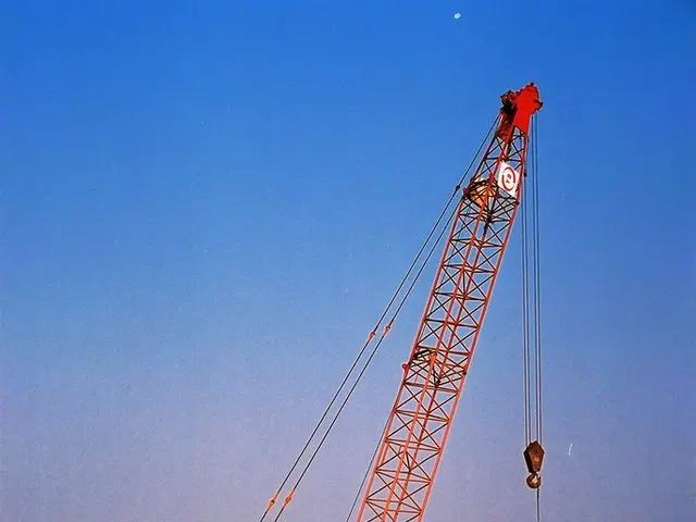 Heavy-duty trucks involved in the process, as a crane lifts a transformer station from the ground...