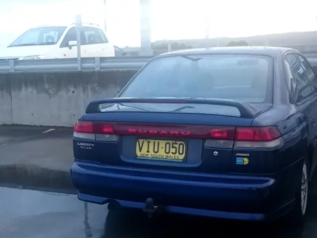 In this image I can see few cars and few poles. Here I can see yellow colour number plate and on it...