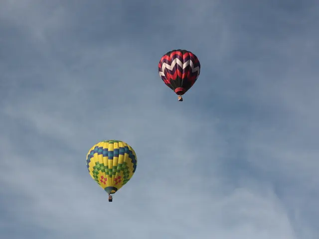 In this image there is the sky, there are air balloons flying in the sky.