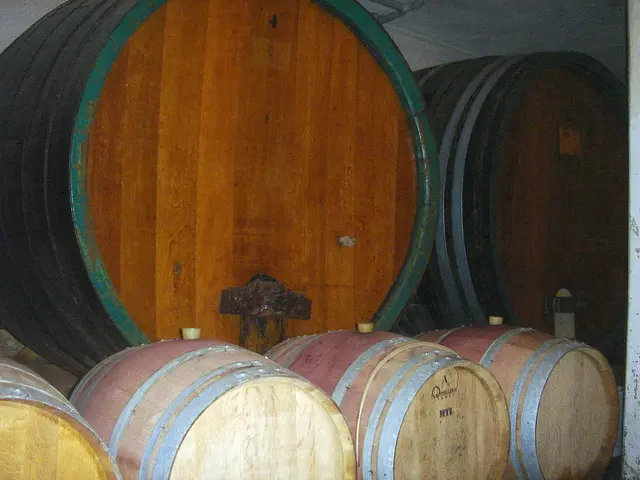 In the center of the image there are barrels. In the background of the image there is wall