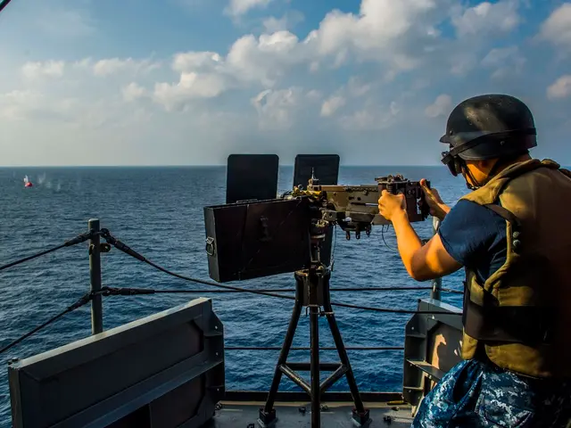 In this image we can see a person holding a machine gun in the ship. In the background we can see...